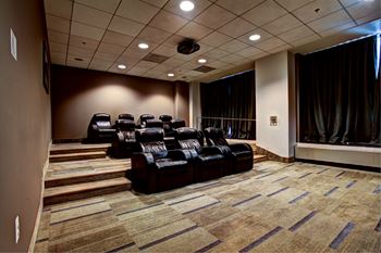 A row of black leather chairs are arranged in a waiting area.